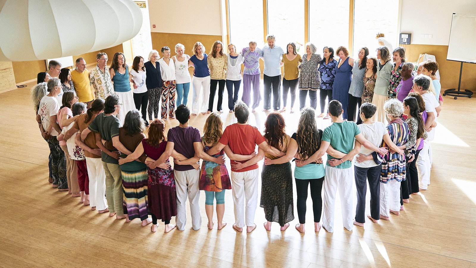 Participants réunis en cercle, bras enlacés, lors d'une séance de Biodanza